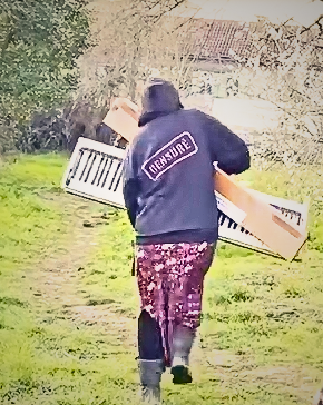 personne de dos qui court avec un piano cassé dans les bras