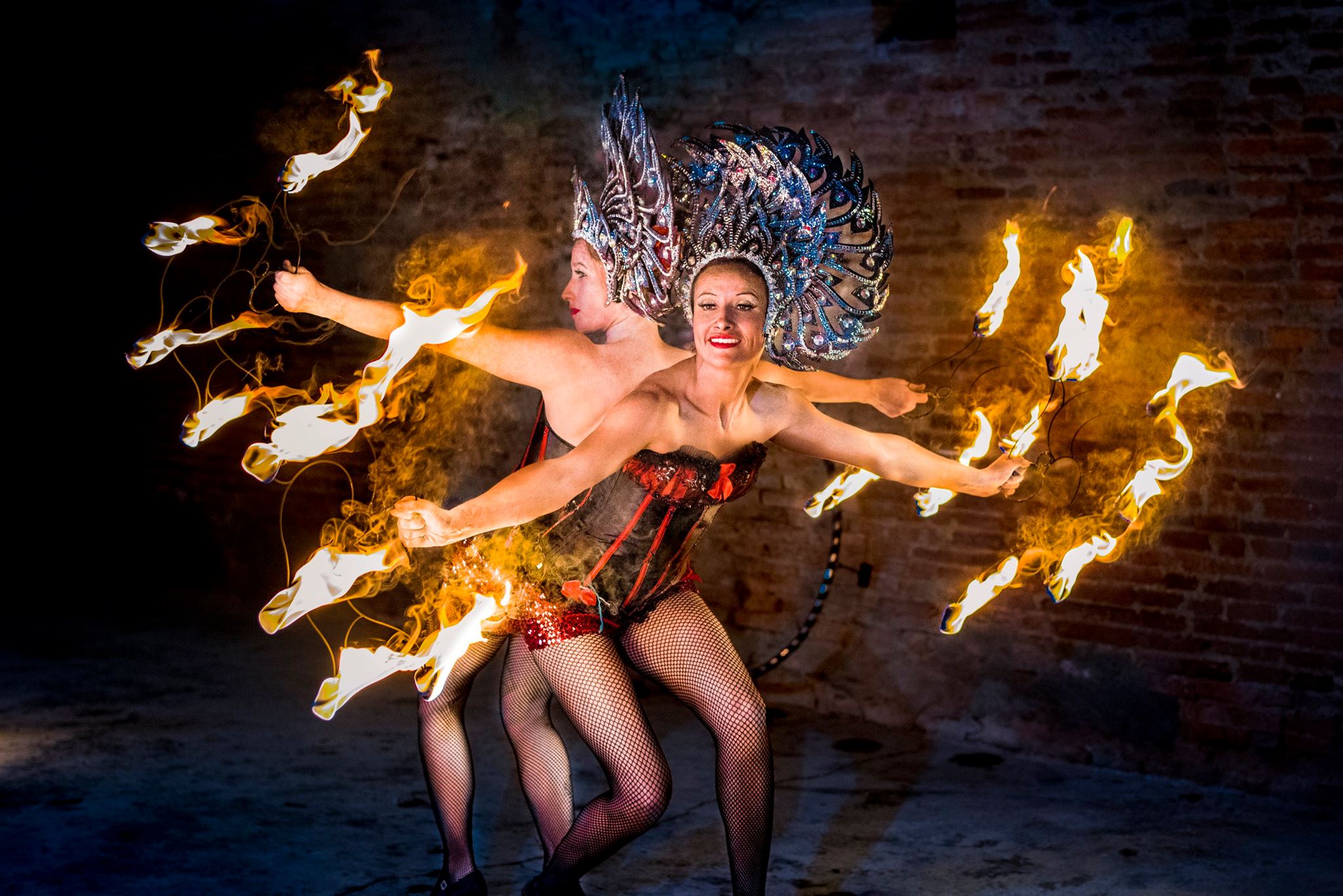 Deux femmes en tenue de cabaret dasant avec des évenatils de feu